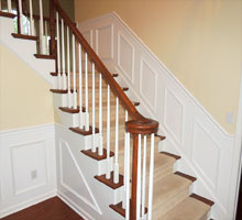 Base of stairs at the foyer with new paint on walls, moldings, risers and balusters.