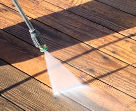 Pressure washing a deck in preparation for new sealant.